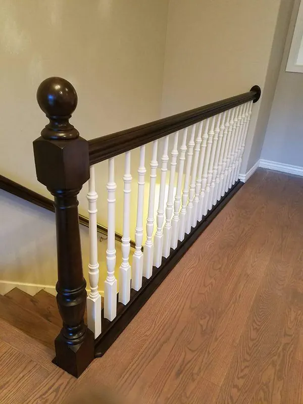 Refinished stair railing with dark handrail and white spindles