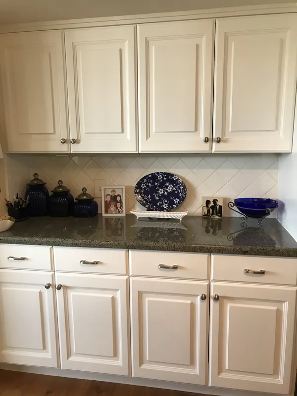 White painted shaker-style cabinets with granite countertops