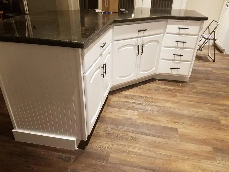 White painted peninsula cabinets with beadboard end panel